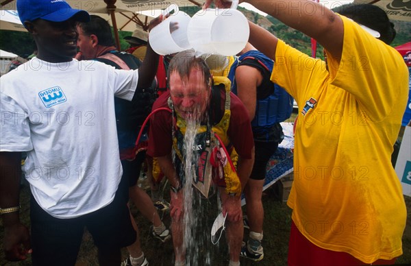 two jugs poured over head of guy with hands on knees