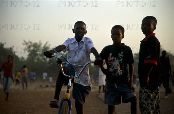 In the suburb of Corofina Nord, Bamako, Mali, young people gather in the late afternoon at a large dusty field to play sport - basketball and soccer - socialise, and play. The field seems to be the centre of social life in the area. 

Young boys come out to play on bikes or with a soccer ball