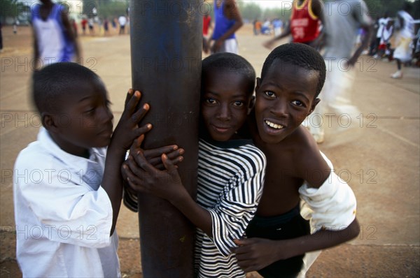 In the suburb of Corofina Nord, Bamako, Mali, young people gather in the late afternoon at a large dusty field to play sport - basketball and soccer - socialise, and play. The field seems to be the centre of social life in the area. 

Young boys spectate a game of basketball