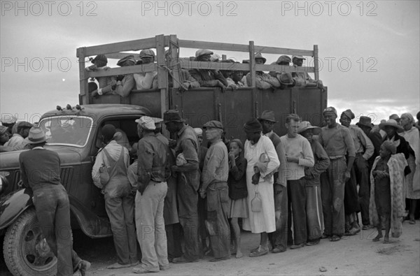 Vegetable workers, migrants, waiting after work to be paid. Near Homestead, Florida 19390101