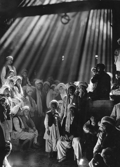 Photograph of rays of sunlight shine on men and boys