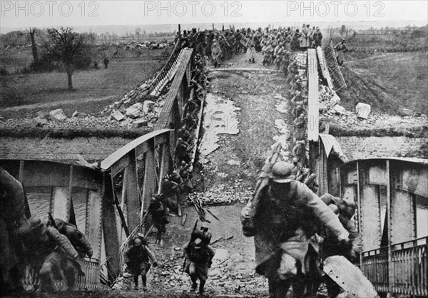 World war One: French troops climb across a ruined bridge 1915