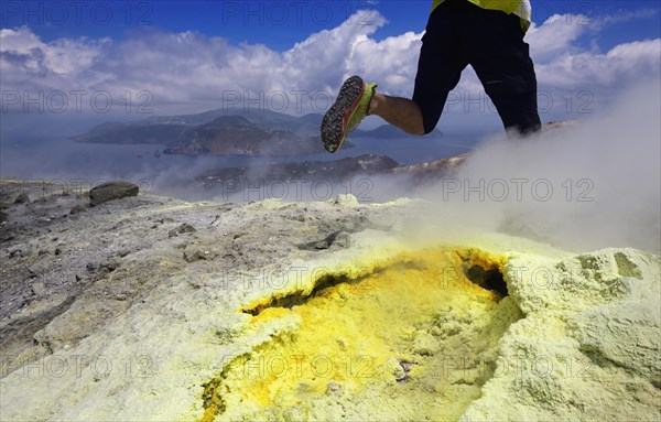 Trailrunner surrounded by sulfur fumaroles and chloride crusts on the crater rim