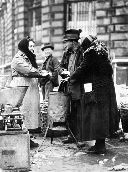 Humans warm themselves at wood stove approx. 1930