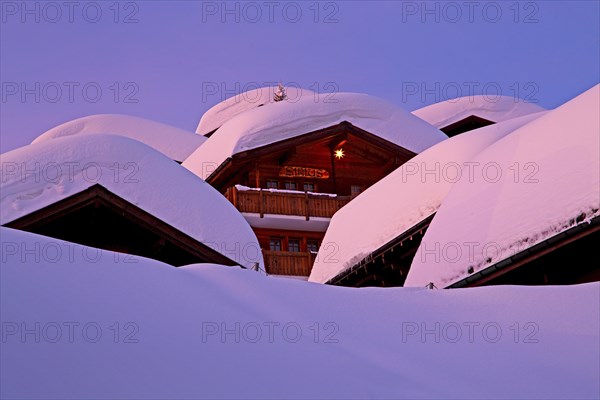 Chalets with deep snow in the village at dusk
