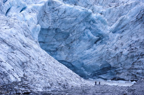 Tourist hiking to the giant glacial outflow of Fox Glacier