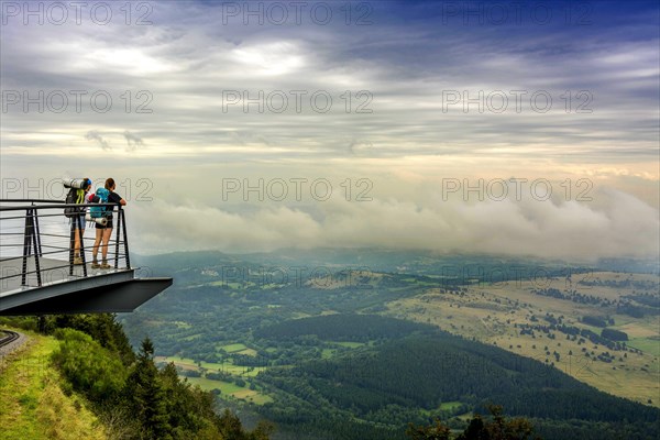 Walkers on a viewing platform facing the Limagne plain Regional Nature Park of the Volcanoes of Auvergne