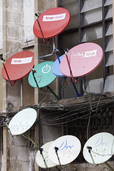 Colourful satellite dishes on a building