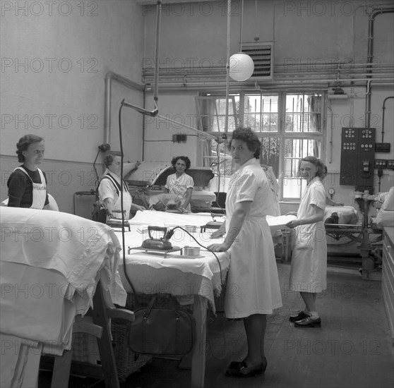 Women folding and ironing textiles