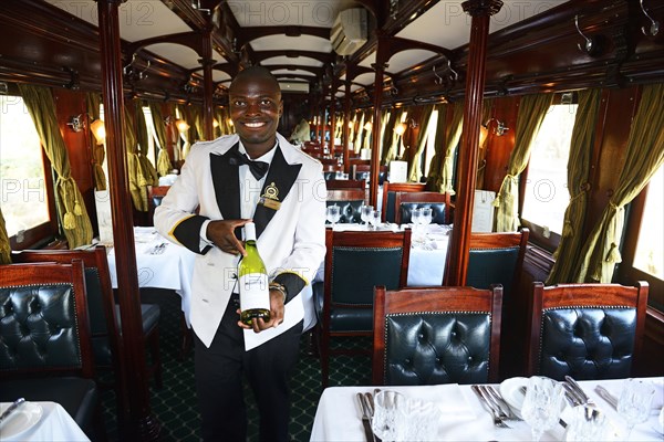 Service staff with wine selection in luxury train