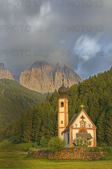 Church of St. Johann with cloudy Geislerspitzen in the background