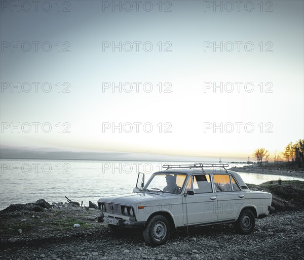 Man in the car on the beach