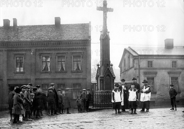 Village square with priest and altar boy ca. 1930