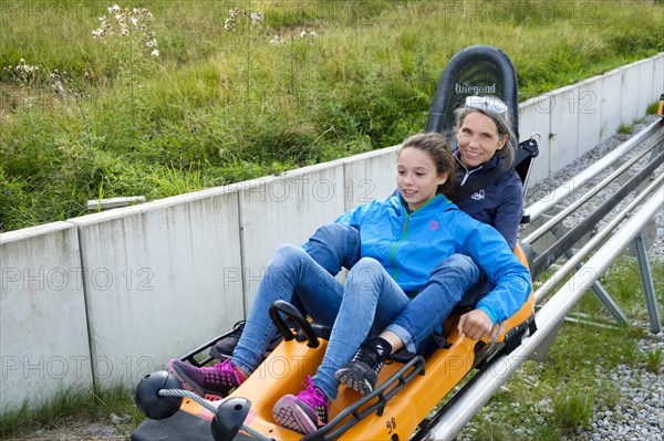 Mother and daughter enjoying a ride with the Alpine Coaster