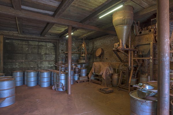 Production room for bronze powder with barrels and machines in a historical metal powder factory