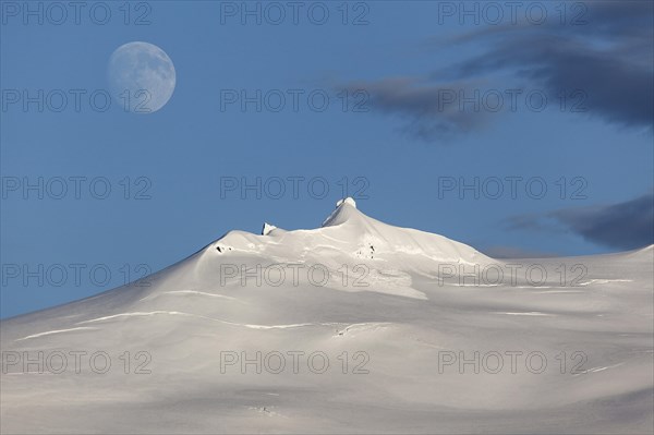 Snow-covered Snaefell volcano with Snaefellsjokul glacier and full moon