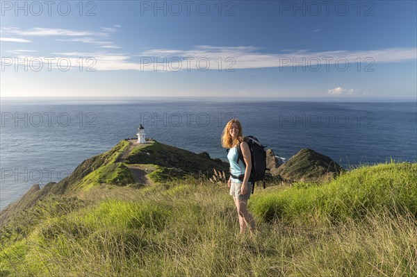 Woman stands in front of lighthouse at Cape Reinga