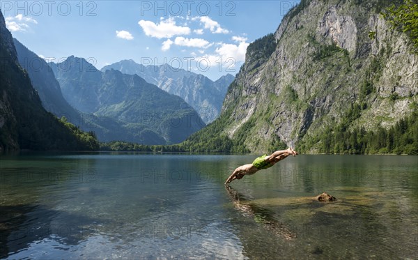 Young man jumps in lake Obersee