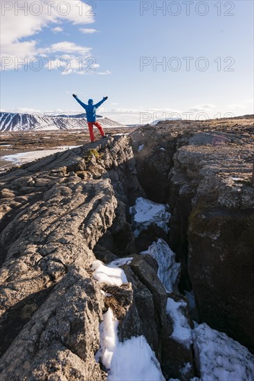 Man stands at Continental Rift between North American and Eurasian Plate