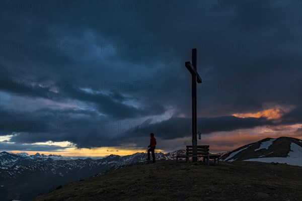 Summit cross Sattele with climber at sunrise