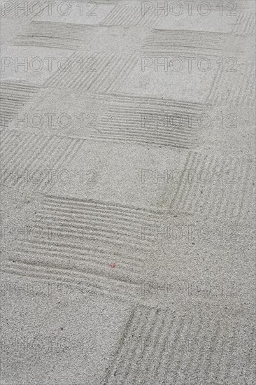 Checkered design on white gravel of a Kaizando hall Zen garden