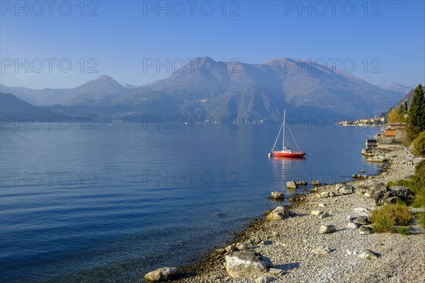 Red sailing boat on the shore