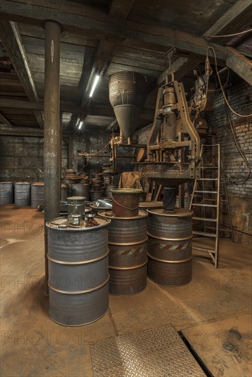 Production room for bronze powder with barrels and machines in a historical metal powder factory