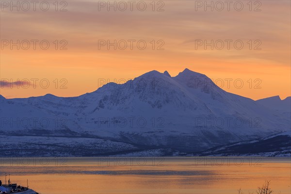 Tromsoysund with snowy mountains at sunset