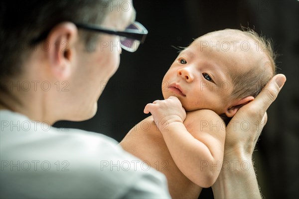 Happy father holding with love his 3 weeks old son