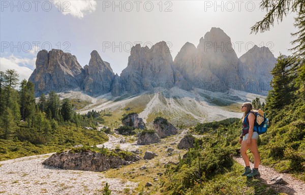 Hiking on footpath to the Geisleralm in the Villnos valley below the Geisler Peaks