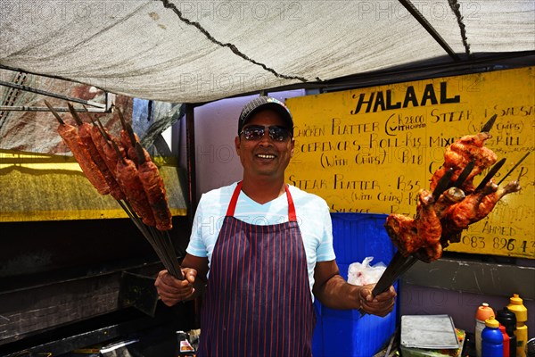 Street stall salesman with skewers