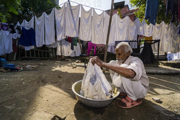 Man doing laundry by hand in courtyard