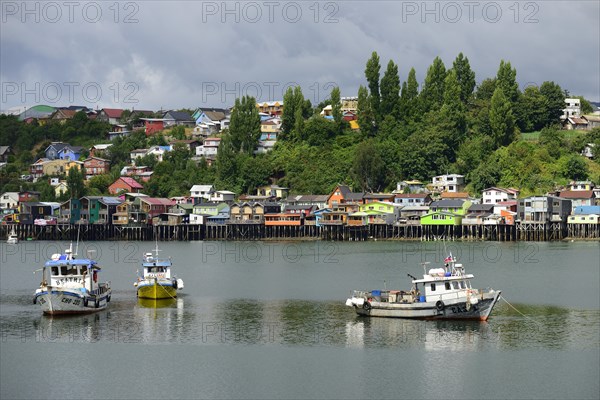 Fishing boats anchoring in front of colorful stilt houses