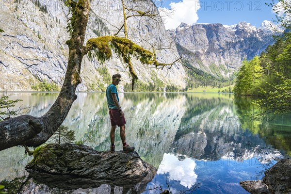 Young man standing on stone in water