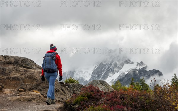 Female hiker on hiking trail in autumnal mountain landscape