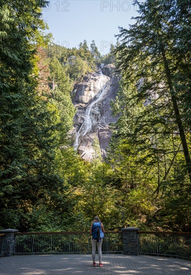 Young woman standing in front of Shannon Falls