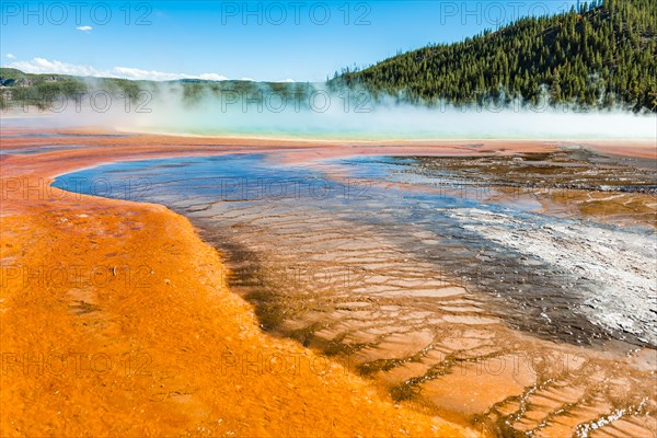 Colored mineral deposits at the edge of the steaming hot spring