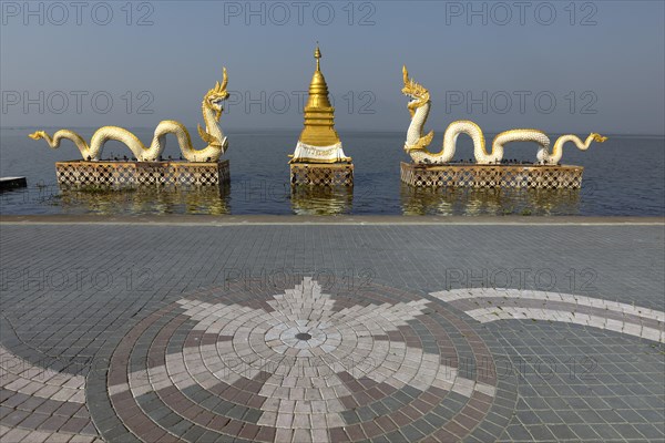 White Naga statues with golden Chedi on the shore of Lake Kwan Phayao