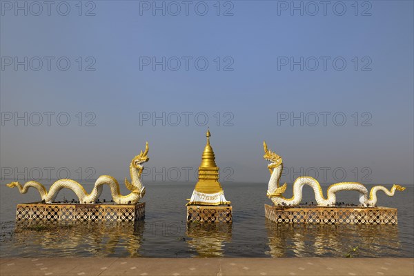 White Naga statues with golden Chedi on the shore of Lake Kwan Phayao