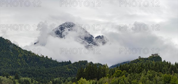 Castle ruin Ehrenberg with deciduous forest and mountains in the fog