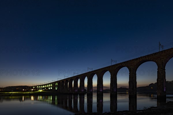 Illuminated railway bridge at night