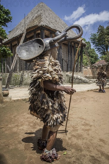 Dancer in traditional clothing wearing carved mask