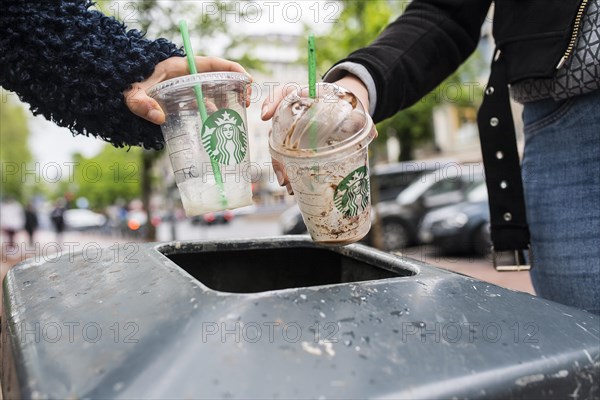 Teenagers throw plastic cups into dustbin