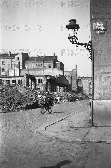 Woman on a bicycle riding through ruins