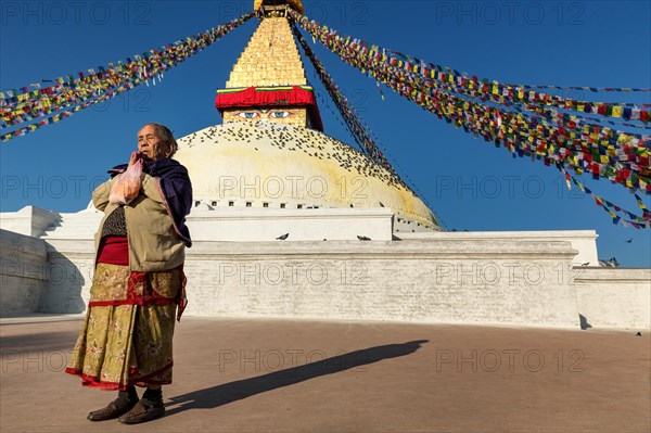 Woman praying in front of Boudhanath stupa