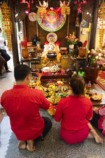 Couple offering offerings in the courtyard of the temple Wat Phnom Daun Penh