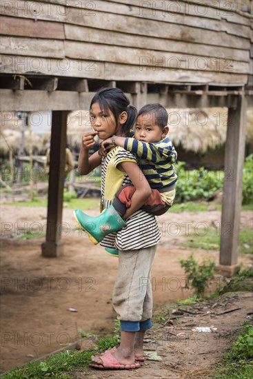 Girl carrying a young boy on her back