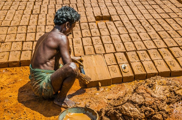 Indian man making clay bricks