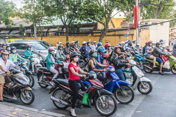 Crowd of scooter riders waiting at traffic light