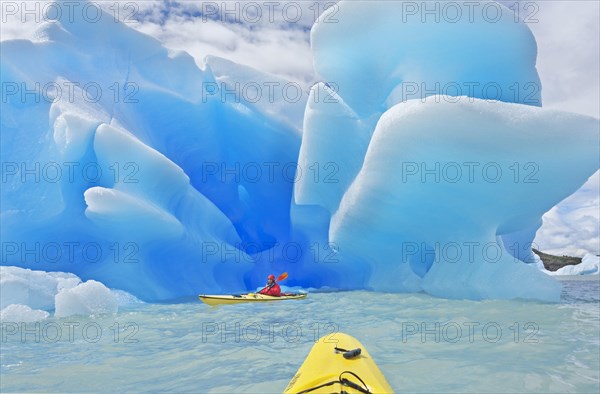 Kayaker heading for icebergs on lake